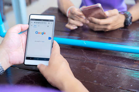 June 12, 2020 Bangkok, Thailand : Asian men is typing on Google search engine from a smartphone. Google is the biggest Internet search engine in the world.のeditorial素材