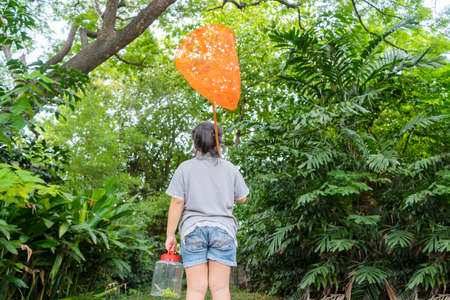 An Asian girl Portrait, she is adventuring in a wide world. Along with a bug catcher. She is walking into the forestの写真素材