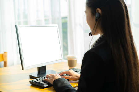Call center concept. Asian business women are talking to their customers online, using computers to help with workの写真素材