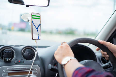 Asian men are driving and using maps on their smartphones.