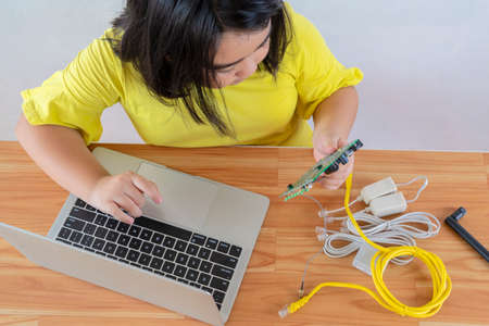 An Asian girl uses a laptop to install a Circuit board. Origins of education for children. STEM Education for kids.の写真素材