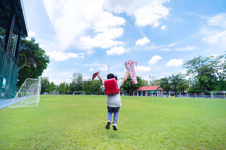 Back to school concept. The girl jumps for joy, she is on her way to schoolの写真素材
