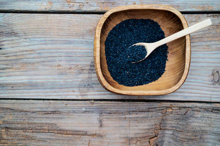 Heap of black Sesame close-up shot on wooden tableの写真素材