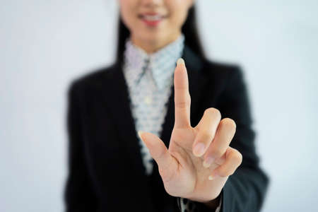 Business women use their index fingers to touch, White isolated backgroundの写真素材