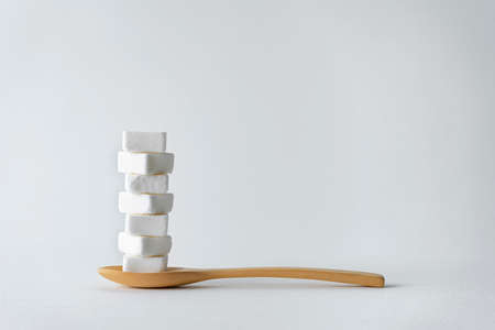 Spoon scoop sugar cubes Isolated on gray background, An empty space to insert ad text.の写真素材