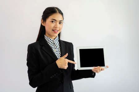 Portrait of an Asian businesswoman wearing a black suit. Hold an empty tablet to put text, images....