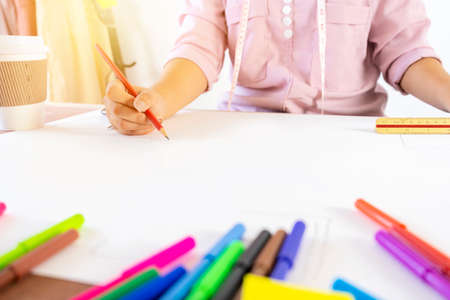 Asian women designers are using pencils to design works on paper.の写真素材
