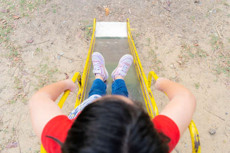 Cute asian child girl having fun to play slider in the playground in summer timeの写真素材