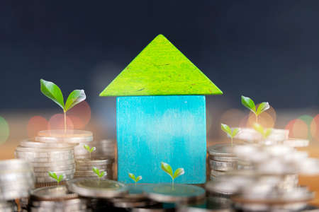 house model on coins saving for concept investment mortgage fund finance and interest rate home loanの写真素材