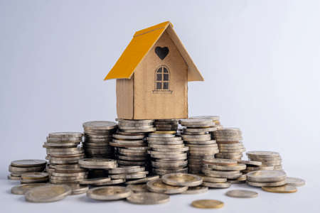 House on a pile of coins. Mortgage real estate concept. Investment, save money or future home.Contracting for housing.の写真素材