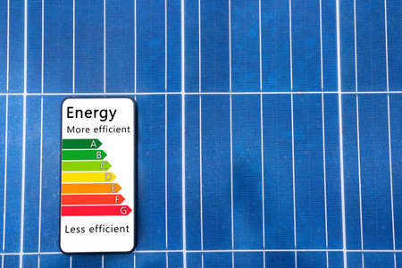 Solar panel, photovoltaic, alternative electricity source - concept of sustainable resources. Detail of house efficiency rating on digital smartphone screen saver.の写真素材
