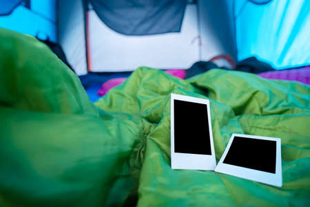 Two polaroids were placed on a sleeping bag in the tent, To record the memories of the tripの写真素材