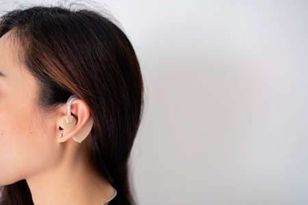 Asian women listening with her hand on an, Hearing test showing ear of young womanの写真素材