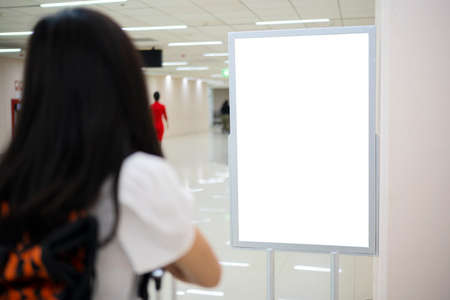 Asian women tourists stand and watch the billboards. A blank billboard to put textの写真素材