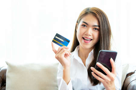 Beautiful Asian girls who shop online with credit card using digital smartphones to shop onlineの写真素材
