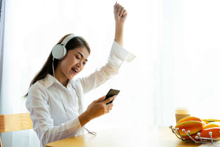 Happy business women relax bright enjoying the music at home, relaxing moments from work.の写真素材