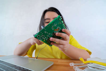 Asian women are learning simple electrical circuits. By learning from the laptop searching for information on how to connect the circuitの写真素材