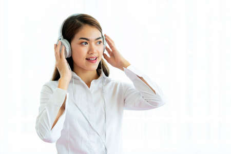 Young beautiful woman in bright outfit enjoying the music at homeの写真素材