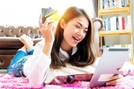 Picture showing pretty woman shopping online with credit card, using digital tablet to shop onlineの写真素材