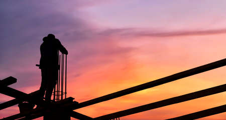 Silhouette of engineer and construction working at site over blurred background for industry backgroundの写真素材