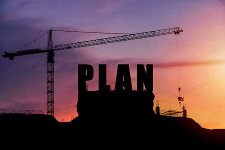 Cranes building construction, cooperate for successful work. Silhouette staff works as a teamの写真素材