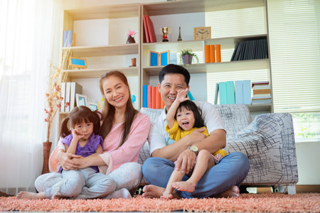 Happy family with daughters playing at home and weekend for familyの写真素材