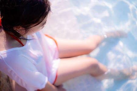Top view beautiful young woman posing by the pool in tropical resortの写真素材