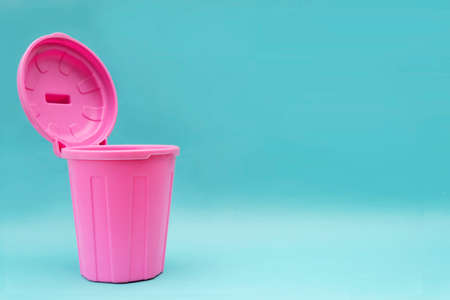 A pink mock-up trash can with an open lid and it is open on a blue background. There is a blank space to insert textの写真素材