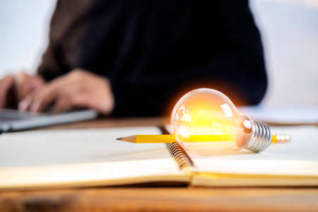 A light bulb is placed on book for reading, acquiring knowledge and finding new ideas. Education conceptの写真素材