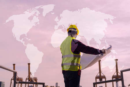 An engineering consultant, a construction site man with a blueprint in his hand International shipping inspector With graphic mapの写真素材
