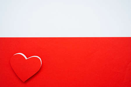 Red paper hearts isolated on red background On the bottom left there is an empty space for inserting text.の写真素材