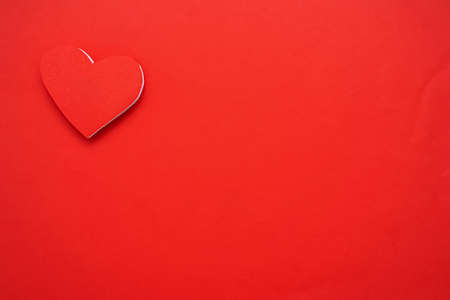 Red paper hearts isolated on red background. On the top left there is an empty space to insert text.の写真素材