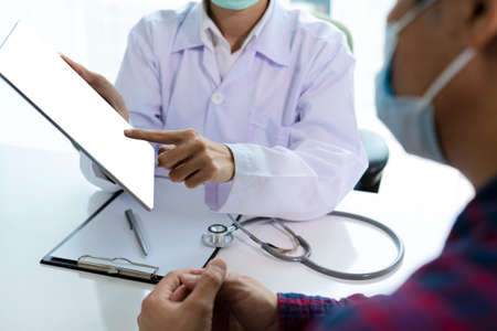 Woman doctor using tablet computer while. Doctor consultation with the patient by using digital tablet in hospitalの写真素材