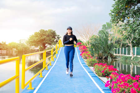 Athlete running on the road trail training for marathon and fitness. motion blur of woman exercising outdoors, young fitness woman runner athlete running at roadの写真素材