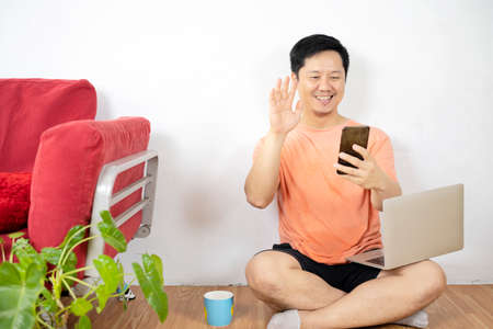 Coffee morning in video call screen. Morning coffee break during work from home. Man working on computer in office. Video conference remote call. Business internet telework drinking coffee.の写真素材