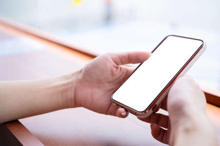 Female hands holding phone with isolated screen at outdoor, close up. Use of mobile conceptの写真素材