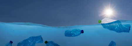 plastic waste at the ocean, a plastic bottle floating in the Mediterranean sea at the water surface, environmental problem with plastics pollution, copy space for text. panorama conceptの写真素材