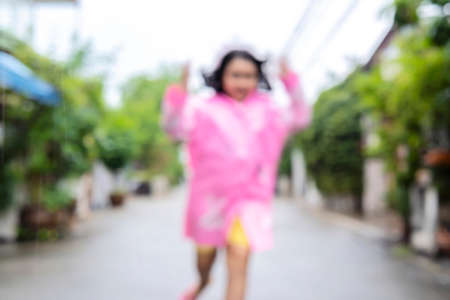 Blur background. Happy asian little child girl having fun to play with the rain in the eveningの写真素材