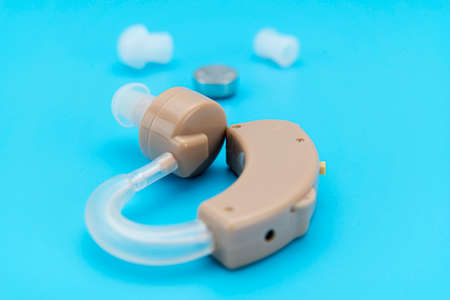 Hearing aid with device and charcoal on blue background.の写真素材