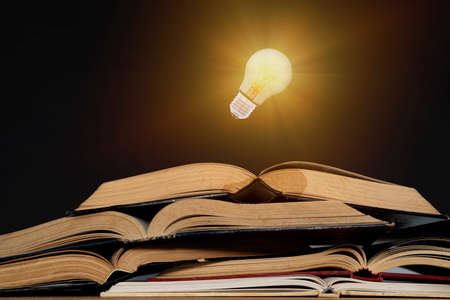 Light bulb and opened vintage book style vintage dark background,The idea of reading books, knowledge, and searching for new ideas,book bible.Conceptの写真素材