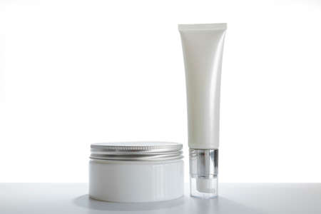 Mock-up two empty container cream pump bottles and a cream jar for skincare is uncover, isolated on white backgroundの写真素材