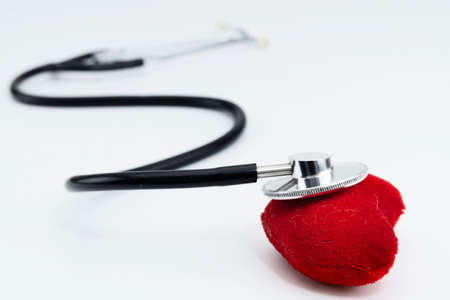 One single alone red heart love shape hand exercise ball with bandage MD medical doctor physician's stethoscope white wood background: Hospital life insurance concept: World heart health day ideaの写真素材