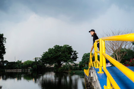 Runner doing stretching exercises in a bridge over a lake in the park.の写真素材
