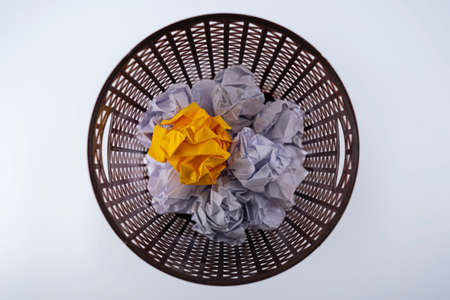 The yellow crumpled paper that was thrown into the trash As if you were throwing away a good idea, missing a good opportunity.の写真素材