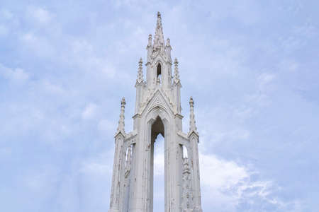 Spire of medieval catholic cathedral on background of sky, dramatic cloudsの写真素材