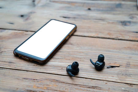 Mobile accessories arrangement band black wireless headphones wireless headphones android mobile top blank wooden backgroundの写真素材