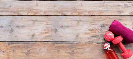 Fitness concept. Dumbbells, water bottle on wooden background. Top view with space for your textの写真素材