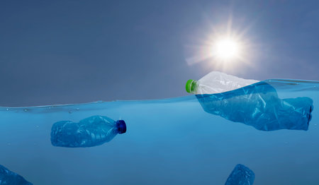 plastic waste at the ocean, a plastic bottle floating in the Mediterranean sea at the water surface, environmental problem with plastics pollution, copy space for text. panorama conceptの写真素材