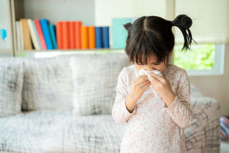 This child is allergic to air or is infected with influenza virus, so he has to cover the tissue to sneeze when sneezing.の写真素材