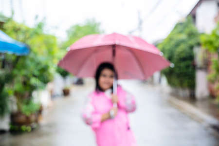 Blur background of Asian child playing with water hose outdoors on a hot sunny summer dayの写真素材